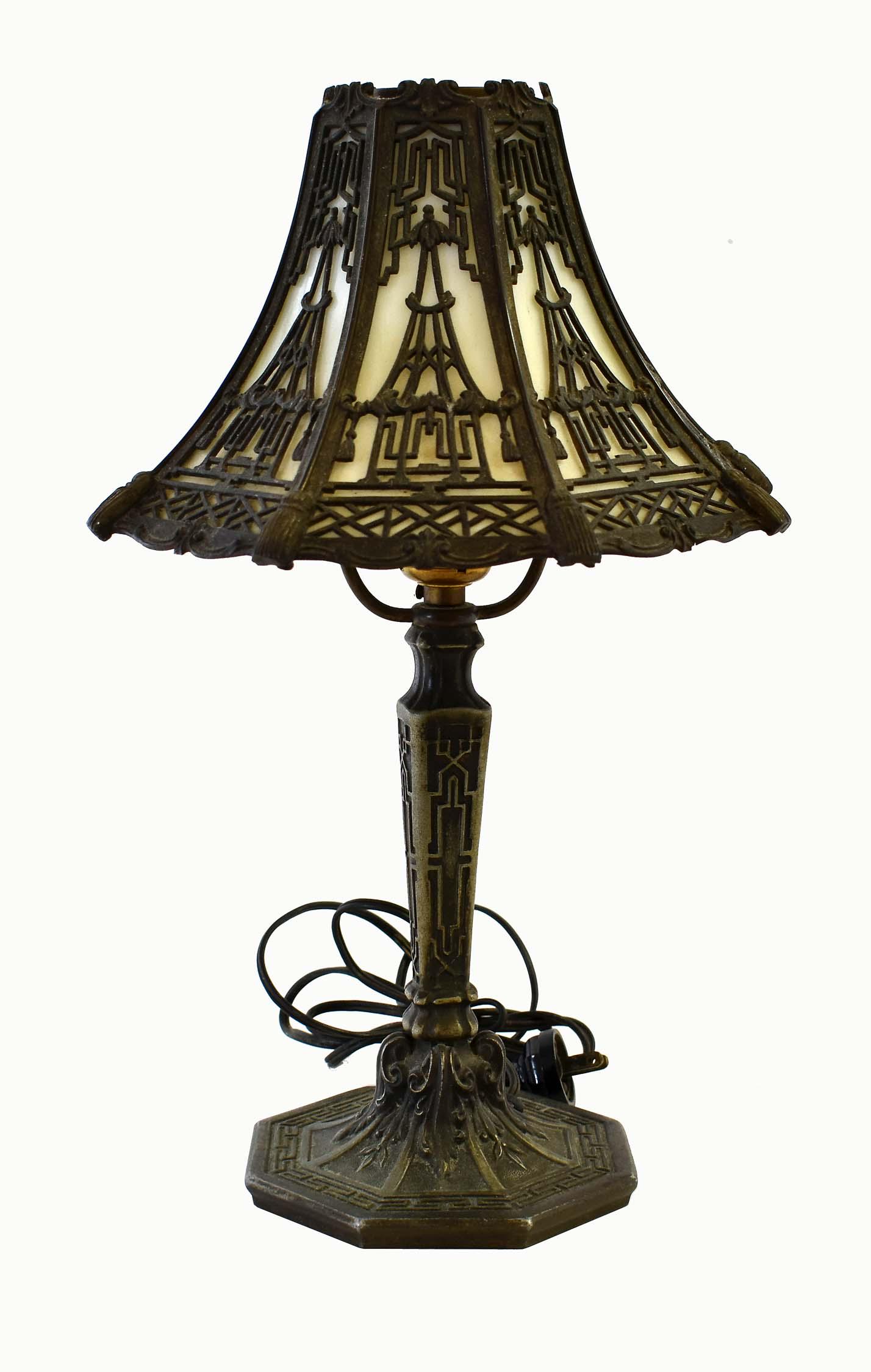 AMERICAN PATINATED METAL AND GLASS BOUDOIR LAMP: The shaped shade with a metal frame cast with stylized pagodas, the standard cast with fretwork in the manner of Thomas Chippendale.