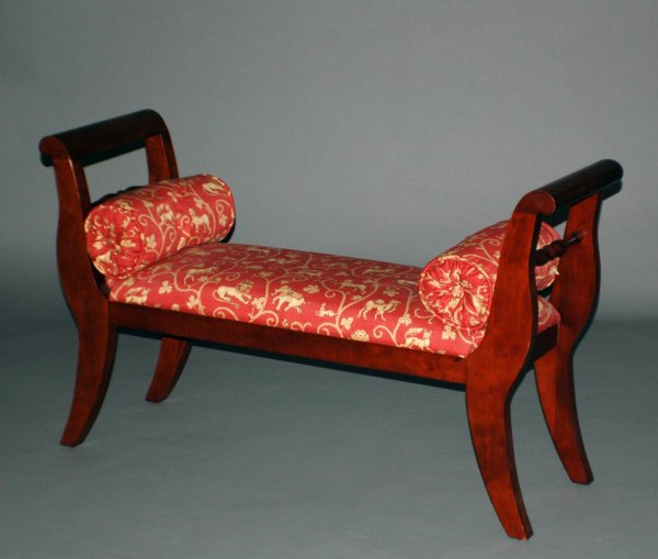 REGENCY STYLE MAHOGANY WINDOW BENCH: The rectangular upholstered seat flanked by curved and rolled arms, raised on shaped legs. Length 49. (400/500)