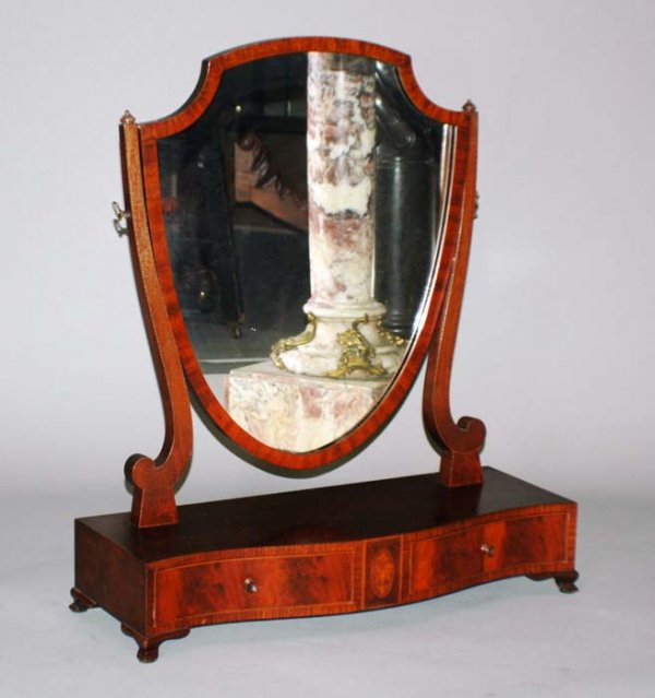 REGENCY STYLE INLAID MAHOGANY SHAVING MIRROR: English. Late 19th Century. The shaped case fitted with two drawers supporting an adjustable shield form mirror. Height 27 1/2". Width 24". Depth 9". (300/500)