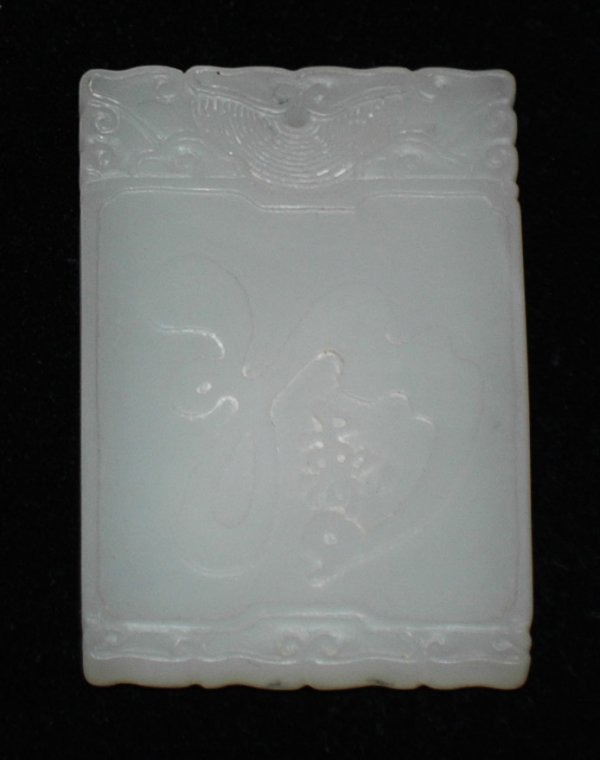 FINE CARVED WHITE JADE PLAQUE: Chinese. 18th/19th Century. The small rectangular plaque carved in shallow relief on one side with a female holding a peach blossom, the reverse with calligraphy characters, the stone of even bright w