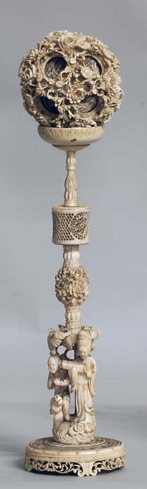 VERY GOOD CARVED IVORY CONCENTRIC BALL ON STAND: Chinese. Early 20th Century. The outer ball carved with chrysanthemums containing the pierced inner balls, supported by a figural stand on a circular base. Height 16". (Cond: some minor cracks to inne