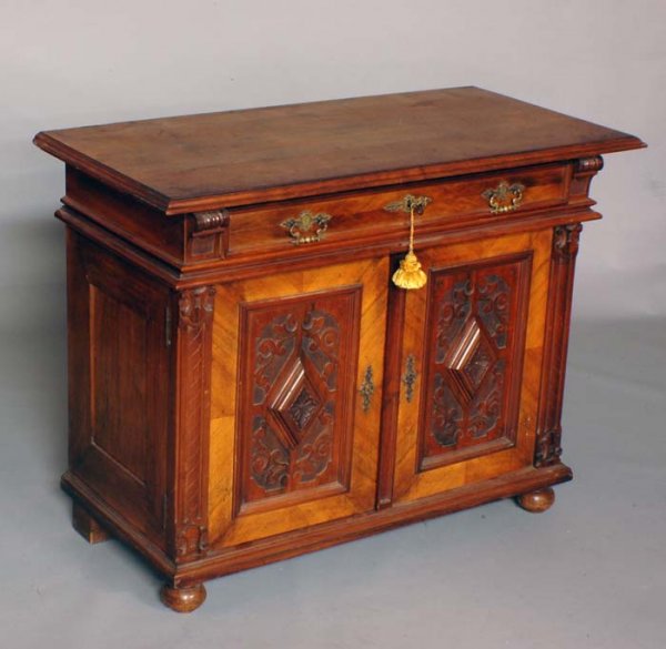 OAK BUFFET: French. Circa 1890. The rectangular molded top above a frieze drawer and a pair of paneled cupboard doors, raised on bun feet. Height 33 1/4". Width 43 1/4". Diameter 21". (500/700)