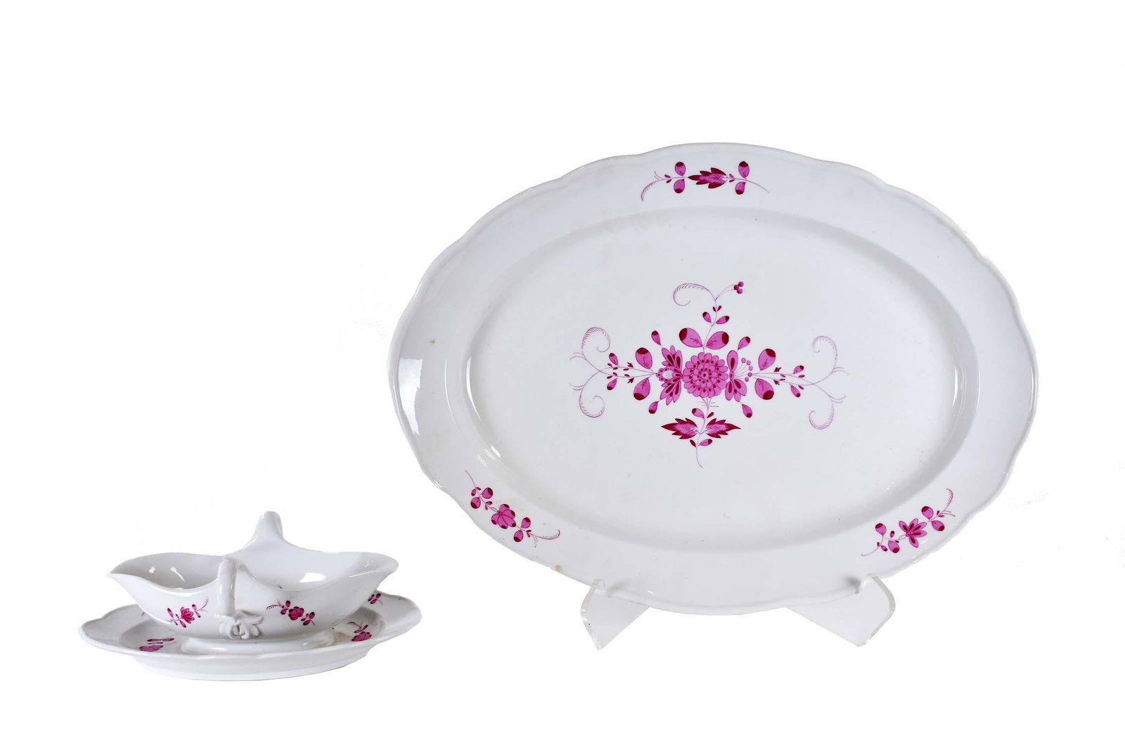 MEISSEN PORCELAIN OVAL PLATTER AND A SAUCE BOAT: Each with cancelled crossed swords in underglaze blue. Decorated with puce foliate sprigs. Length of platter 19 in. Length of sauceboat 10 in.