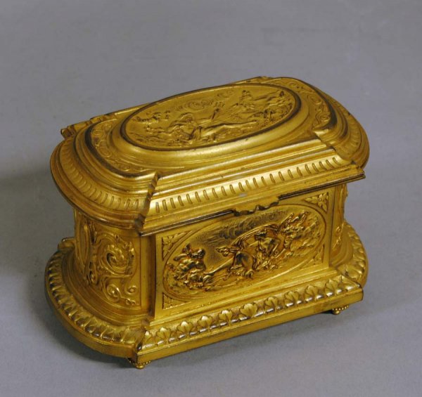 LOUIS XVI STYLE GILT METAL CASKET: Argentinean. Stamped Alberto Vignes, Buenos Aires. Of oblong form, cast with panels depicting Triton, cupids and sirens. Length 4 3/4". (300/400)