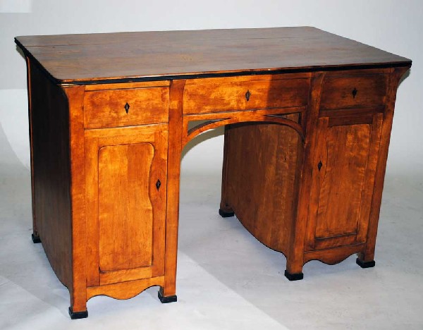 BIEDERMEIER FRUITWOOD PEDESTAL DESK: German. 19th Century. With a rectangular top above three frieze drawers, each pedestal with a cupboard door. Height 32 7/8". Width 51 1/4. Depth 29 1/8". (1000/1500)
