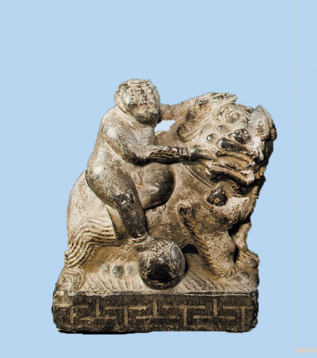 CARVED GRANITE GROUP: Chinese. Of a figure standing on a ball feeding a seated fu lin. Height 6 1/8". (400/600)