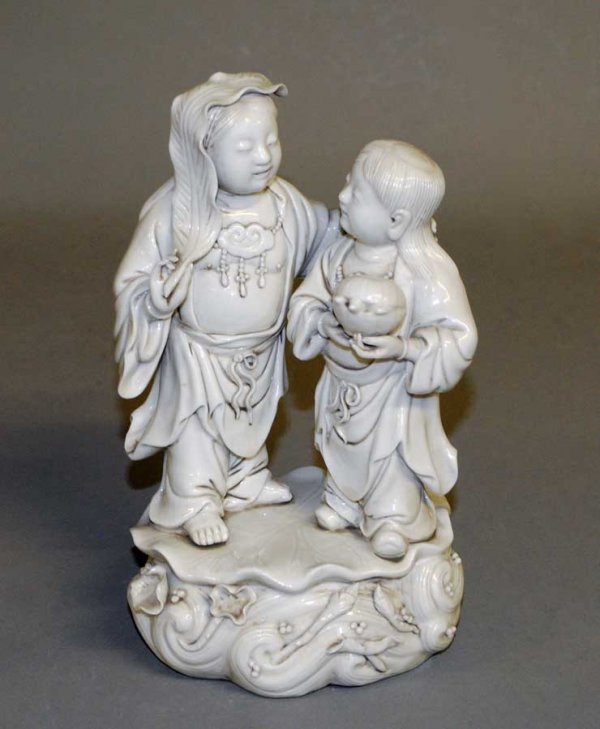 MING DYNASTY BLANC DE CHINE GROUP: Chinese. 17th Century. With seal mark of He Chaozong. Depicting the twin genii of mirth and harmony. Height 9 1/8". (1500/2000)
