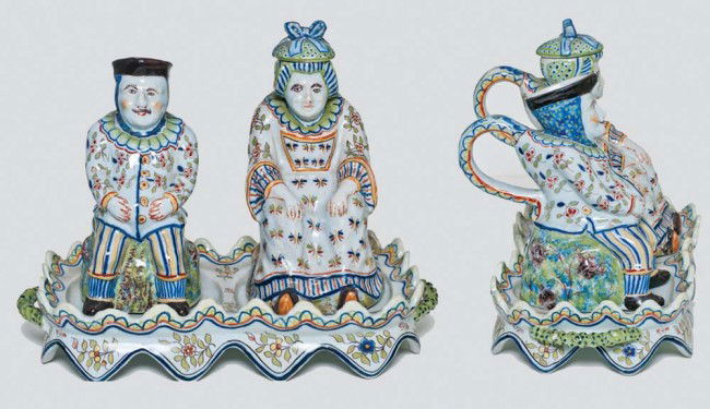 CONT. FAIENCE FIGURAL SALT & VINEGAR WITH STAND: French. Circa 1900. In the form of a seated male and female supported by the shaped stand. Length of stand 11". (300/400)