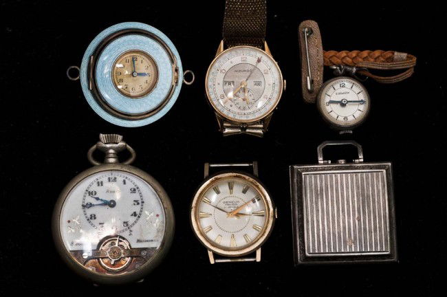 GROUP OF SIX ASSORTED TIME PIECES: Comprising: a silver cased travel clock, a silver and enamel pendant watch, a pocket watch, a lapel watch, a Movado wristwatch, and a Geneve wristwatch. (150/200)