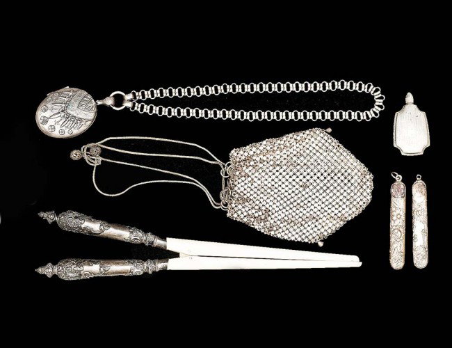 GROUP OF SIX SILVER ARTICLES: Comprising: a double locket with a silver chain, a mesh purse, a parfume bottle, an ivory glove pull with Victorian silver mounts, and two cylindrical form containers. (5 oz) (250/350) (NOTE: INTERNAT