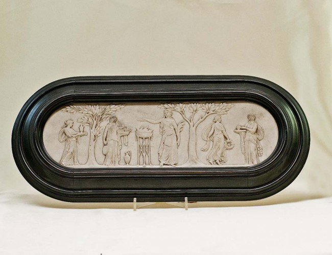 PARIAN WARE PLAQUE: Of oval shape molded with muses. Measuring 3 3/4" by 1 1/4". In an ebonized frame. (150/200)