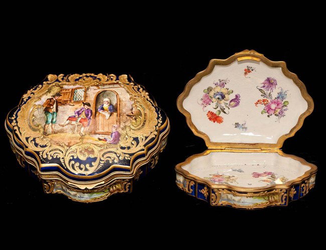 "SEVRES" PORCELAIN BOX: French. Late 19th Century. The hinged cover painted with violin player and a family, enclosed by a raised gilt border, the interior with flower sprays. Length 5 5/8". (250/350)