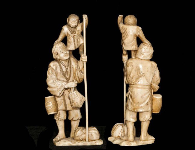 CARVED IVORY GROUP: Japanese. Of a traveler with a monkey on his shoulder carrying his bags and a large staff. Height 7". (300/400) (NOTE: INTERNATIONAL SHIPPING IS NOT AVAILABLE FOR THIS ITEM; ITEM WAS LEGALLY IMPORTED 