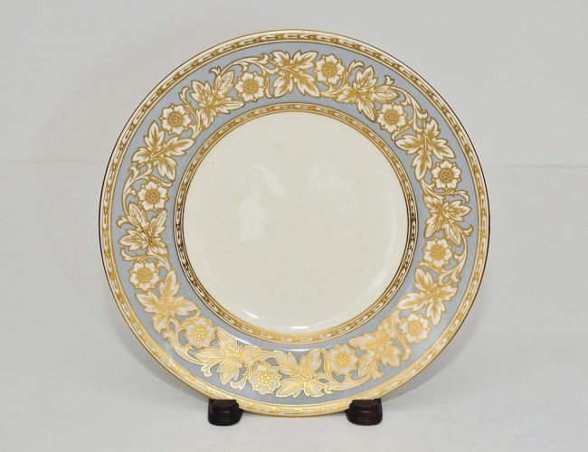 SET OF TWELVE MINTONS PORCELAIN SERVICE PLATES: English. Date mark for 1929. Impressed and printed factory marks and gilt K324. With pale blue and gilt foliate band. Diameter 10 ½". Specially made for Collamore Co. Ltd., New York. (600/800)