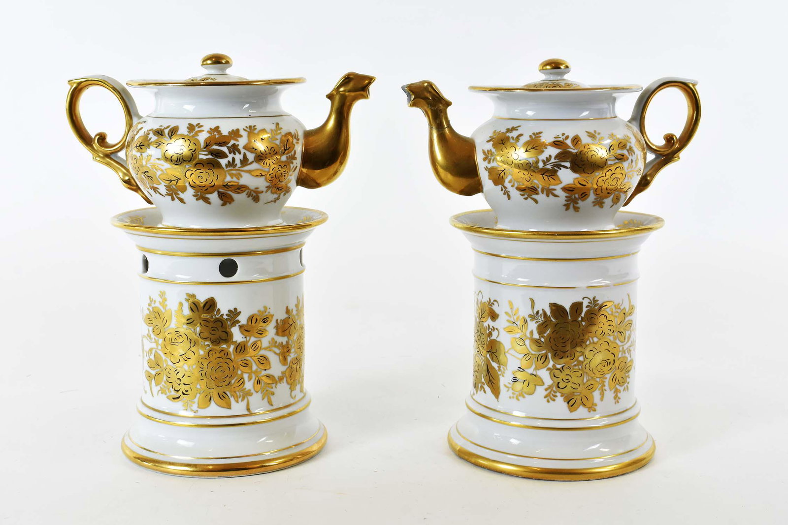 PAIR OF PARIS PORCELAIN GILT DECORATED VEILLEUSE: 19th Century. Each decorated with gilt foliage, the tea pots with a dragon-headed spout, and scrolled handle. Height 8.5 in. (Cond: one spout damaged, badly repaired)
