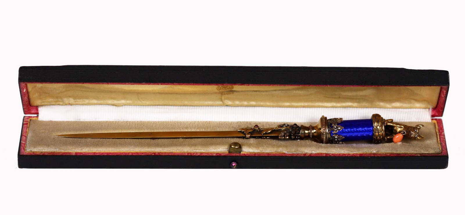 RUSSIAN SILVER-GILT DIAMOND MOUNTED ENAMEL LETTER: Marked, maker appears to be RA. The cylindrical blue enamel handle surmounted by a gilt French bulldog, with diamond inset eyes and a coral pendant, the blade with a foliate strand on each side, set w