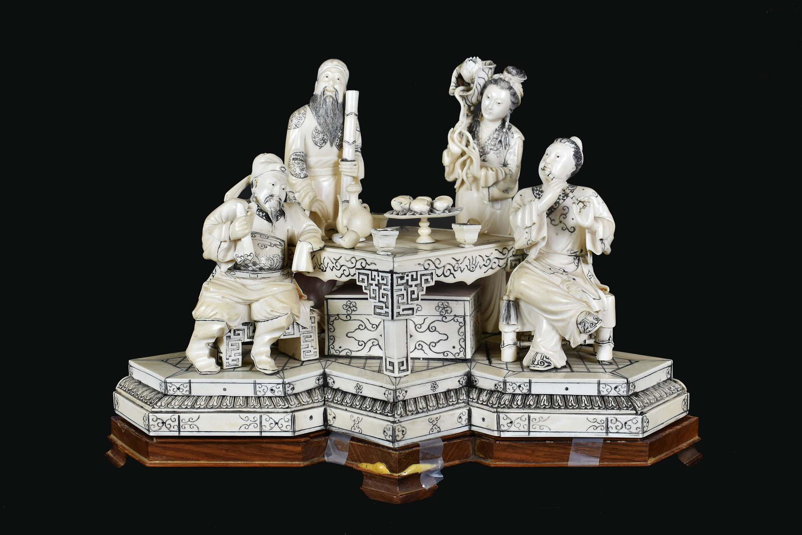 FINE CHINESE ELABORATELY CARVED FIGURAL GROUP: Early 20th Century. The underside with an inset signature plaque. The asymmetrically shaped base simulating a platform with tile inset floor, the figures depicting two maidens and two gentlemen standi