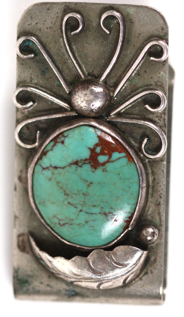 NAVAJO TURQUOISE-MOUNTED SILVER MONEY CLIP: The turquoise with red veins, the silver chased with a leaf and scrolls. Length 1.75 in.