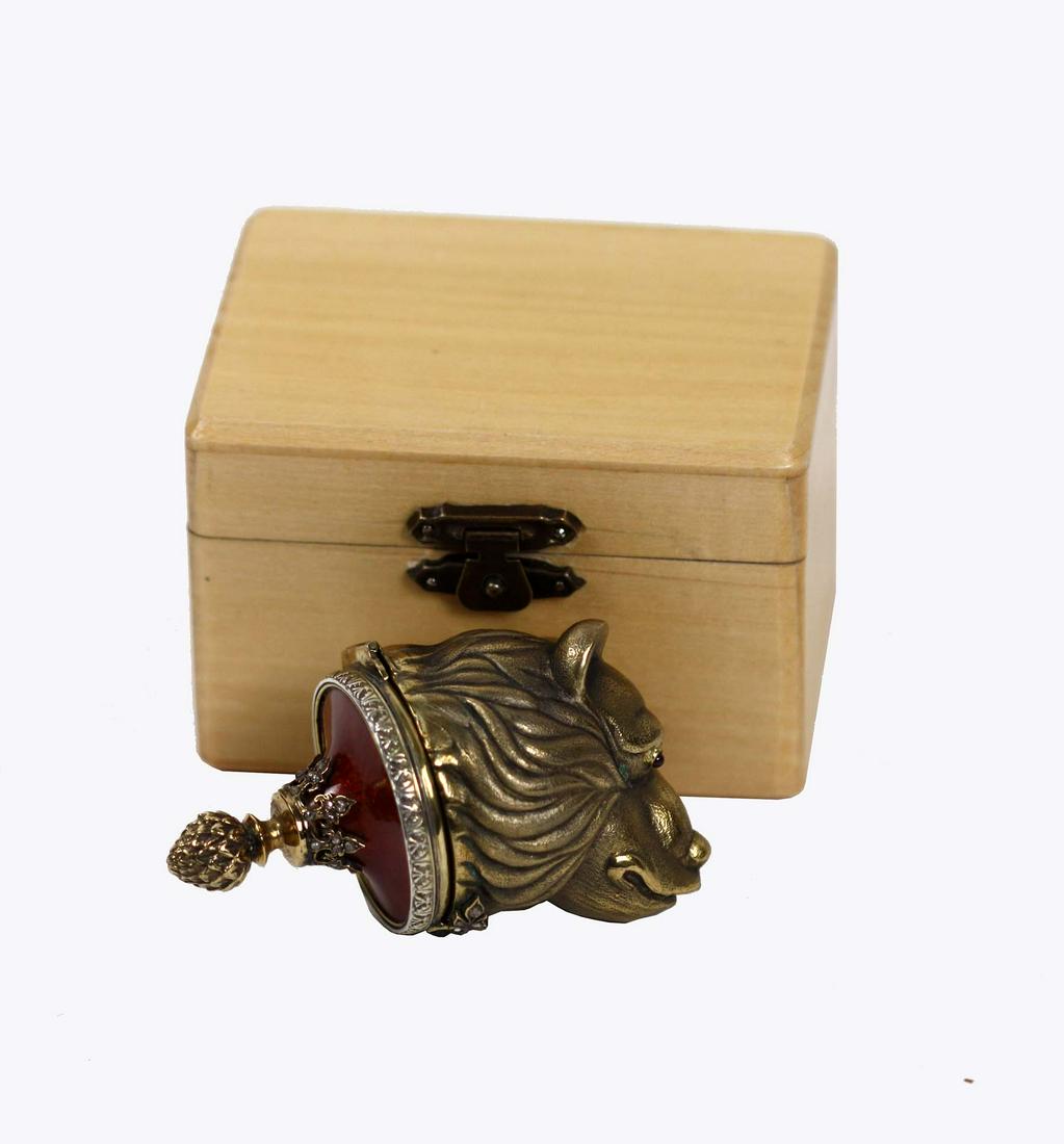 RUSSIAN ENAMELED DIAMOND SILVER GILT PILL BOX: Marked twice, maker IP. Cast as a lion head, ruby-inset eyes, the lid set with red enamel capped with a gilt acorn finial with a lower gilt collar of lambrequins set with diamond chips, in a Cyrillic