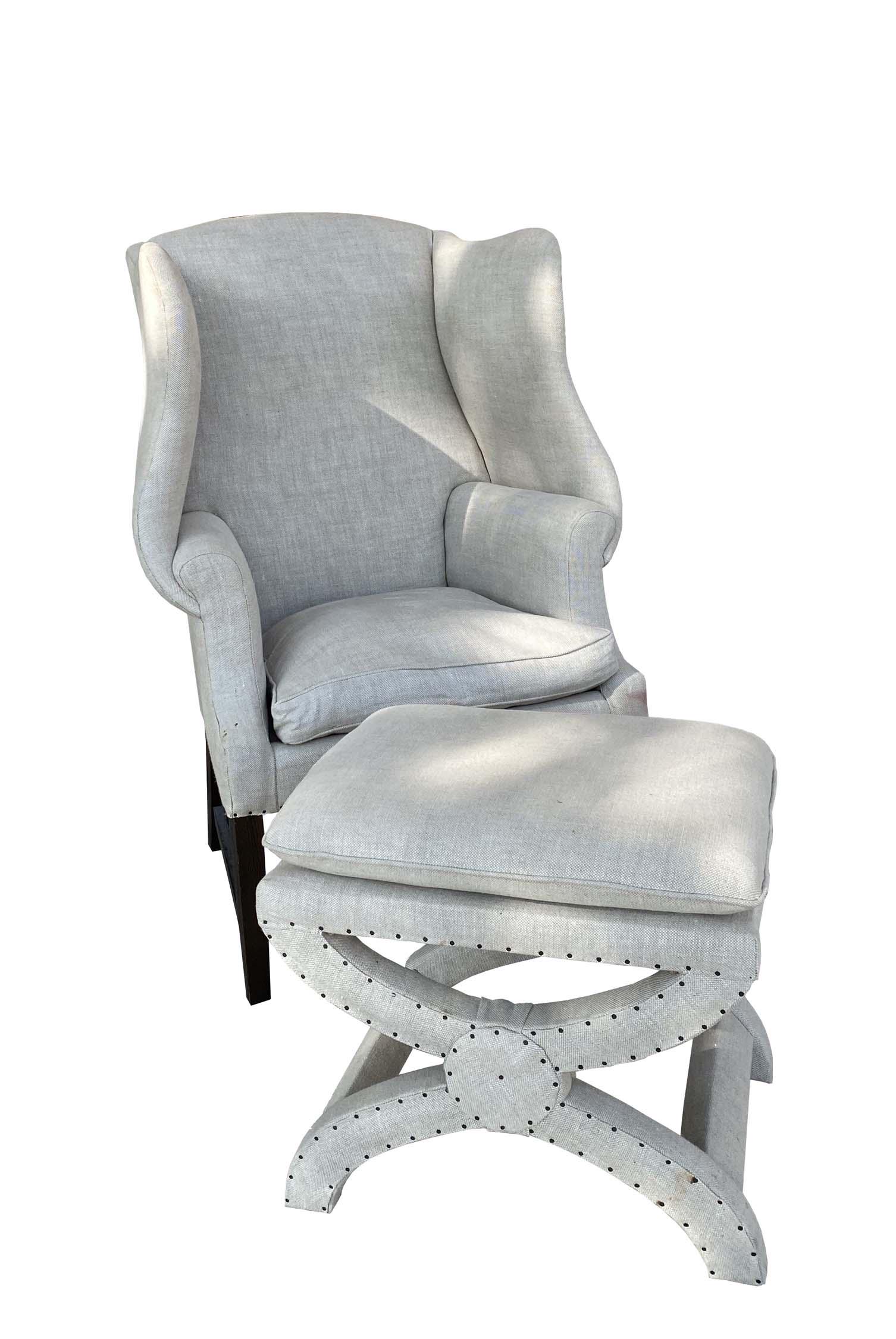 GEORGE III STYLE LINEN-UPHOLSTERED WING CHAIR: The rectangular back and seat with shaped wings. in straight legs. Labeled Restration Hardware. Height back to floor 4 ft. Width 33.5 in. Together with a matching curule foot stool. Height 20 in. Widt