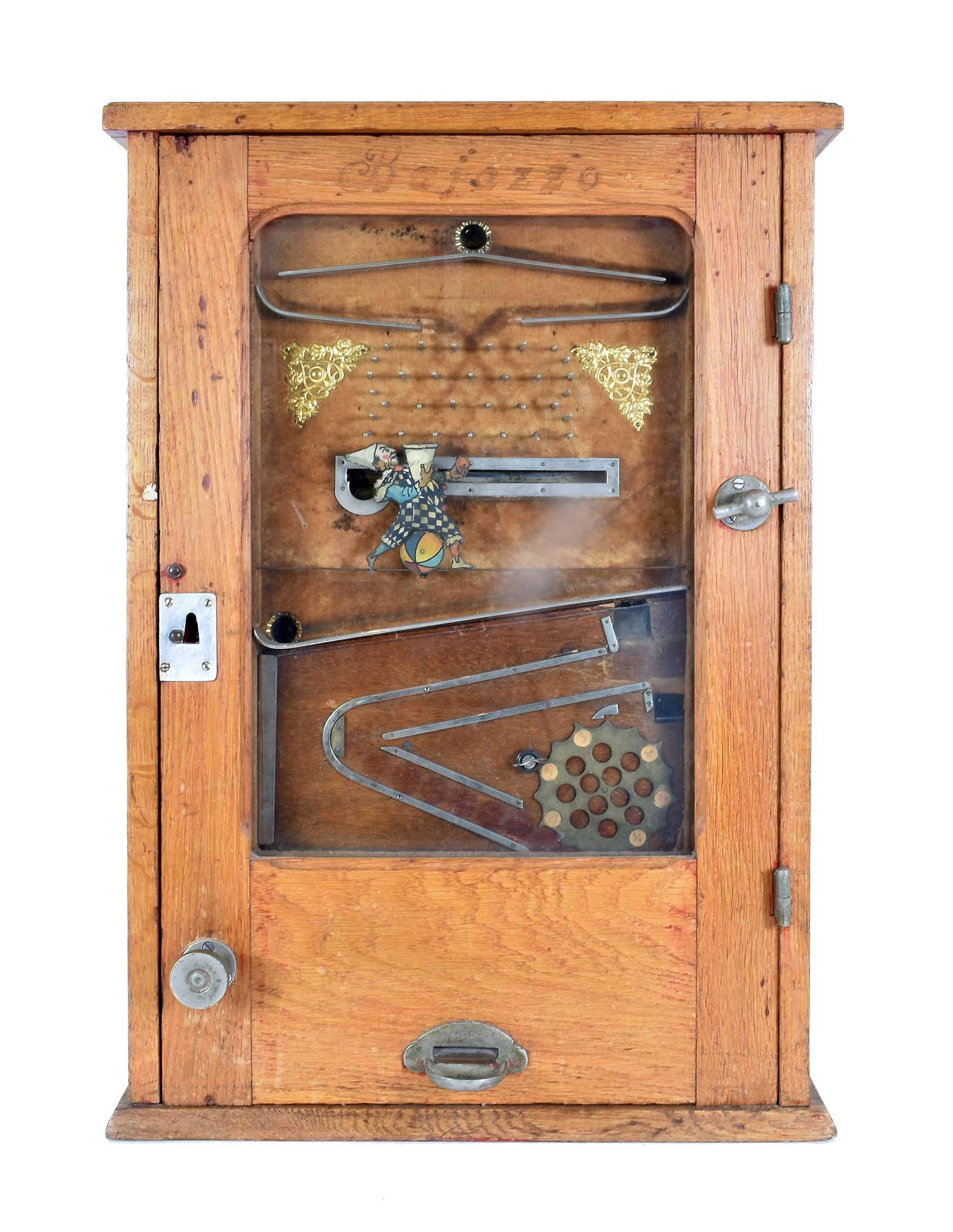 EUROPEAN COIN OPERATED MECHANICAL ARCADE GAME: Circa 1900. The game housed in an oak case with a glazed door, depicting a movable clown running along a slot, controlled by a handle, attempting to catch a ball falling through a pegged flow course, 