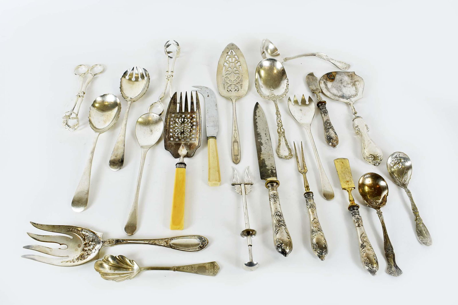 MISC. GROUP OF SILVER PLATE SERVING PIECES: Late 19th/early 20th Century. Including two pairs of salad servers, three sugar spoons, meat fork, two pairs of tongs, a cocktail fork, and other items. (21 pieces)