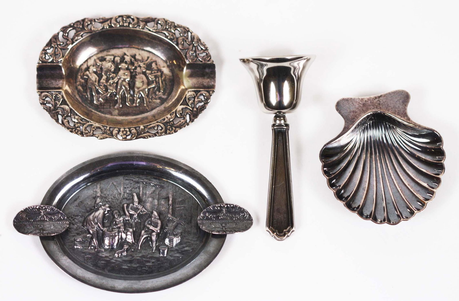 FOUR VARIED SILVER TABLE ITEMS: Comprising a small Tiffany & Co. scalloped shell, marked, two Dutch repousse-decorated ashtrays, and a small dinner bell. Length of largest 4.5 in. Length of scalloped shell 2.75 in. 4.9 Troy oz.