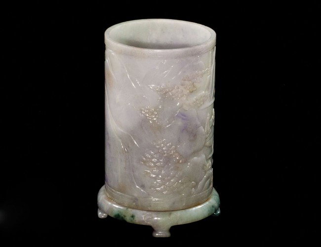 JADEITE BRUSH POT: Chinese. Signed. Of cylindrical form, the lavender stone carved with two men playing Go on a terraced landscape. Height 6 3/8". (2000/3000)