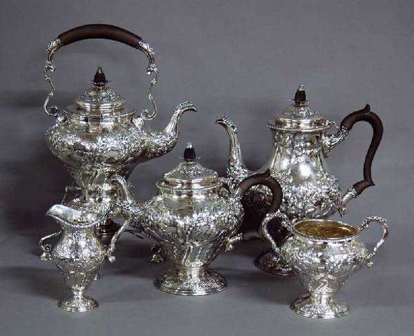 5 PC EDWARD VII STERLING SILVER TEA & COFFEE SVC: English. Chester. 1904. Makers: GN & RH. comprising: tea pot, coffee pot, tilting kettle, creamer and sugar bowl. Each with conjoined monogram. (136 oz) (Cond: coffee pot with slight dent) (4000/5000)