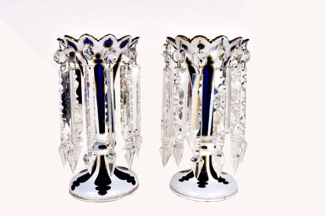 PAIR OF BOHEMIAN WHITE CUT TO BLUE GLASS LUSTERS: Mid to late 19th century. Each tapered body with a scalloped flared rim, on a circular domed foot, hung with colorless glass prisms, gilt highlights. Height 11 in. Diameter at rim 6.25 in. (Cond: lack