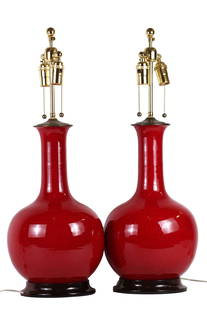 PAIR OF SANG DE BOEUF PORCELAIN VASES AS LAMPS: 20th Century. Each spherical with long necks, the glaze with fine aubergine flecks, drilled, electrified. Height 17 in. Diameter 10.5 in. Height overall 29 in. (Cond: as stated above)