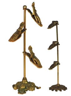 TWO 19th CENTURY BRASS PAPER CLIP HOLDERS: English or French. Each with a scrolled base, with a shaft supporting three hand-shaped paper holders. Heights 18 in., 14 in.