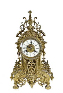 FRENCH BRONZE MANTLE CLOCK: Circa 1900. The circular enamel dial with Roman numerals, encased in a body cast with scrolls and urns, the two-train movement striking the hour and half hour. Height 16 in. Width 9 in. Depth 3.5 