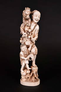 JAPANESE OKIMONO OF A FATHER & SON WITH A MONKEY: Meiji period. The underside signed on a red inlaid plate. The man and his son in a joyful mood, the boy riding his toy horse, the father with a monkey atop his shoulder. Height 12 in. Width 3.5 in.