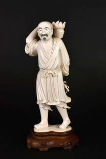 CHINESE MANCHU CARRYING A BASKET OF FRUIT: Republic Period. The underside signed with three characters in black. Dressed in a simple robed head and queue, on a wood stand. Height 9.25 in., overall, 10.5 in.