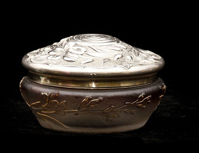 DAUM CAMEO GLASS BOX: French. Circa 1910. Signed in gilt Daum Nancy with Croix of Lorraine. Of circular shape, cut with leaves and flowers, mounted with a silver gilt rim by Gorham and applied with a chased sterling silver