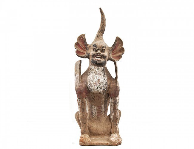 PAINTED POTTERY FIGURE OF AN EARTH SPIRIT: Chinese. Tang Dynasty. 618-907. In a seated position with a body of a lion and legs with cloven hoofs of a deer, with flame-like wings protruding from the shoulders. Height 23 ½". Accompanied by Ther