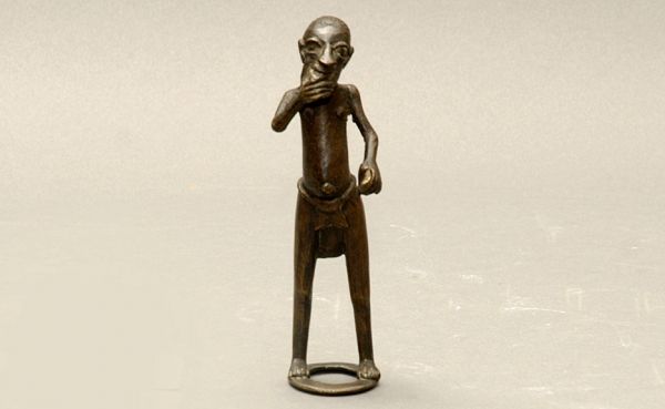 Antique Bronze Tribal man Sculpture: Antique Bronze Tribal 19th C African Tribal Man Sculpture. In Native Dress of loin Cloth with Right hand Raised to MouthStanding on Circular Ring. Measures 7 Inches Tall 2 Inches Wide. Good Condition.