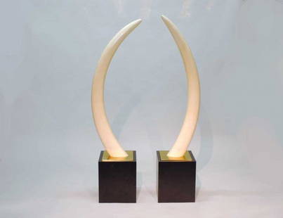 PAIR OF UNCARVED IVORY TUSKS: Each with natural curve. Heights 52" and 53". Mounted on brass and wood stands. (3000/5000)