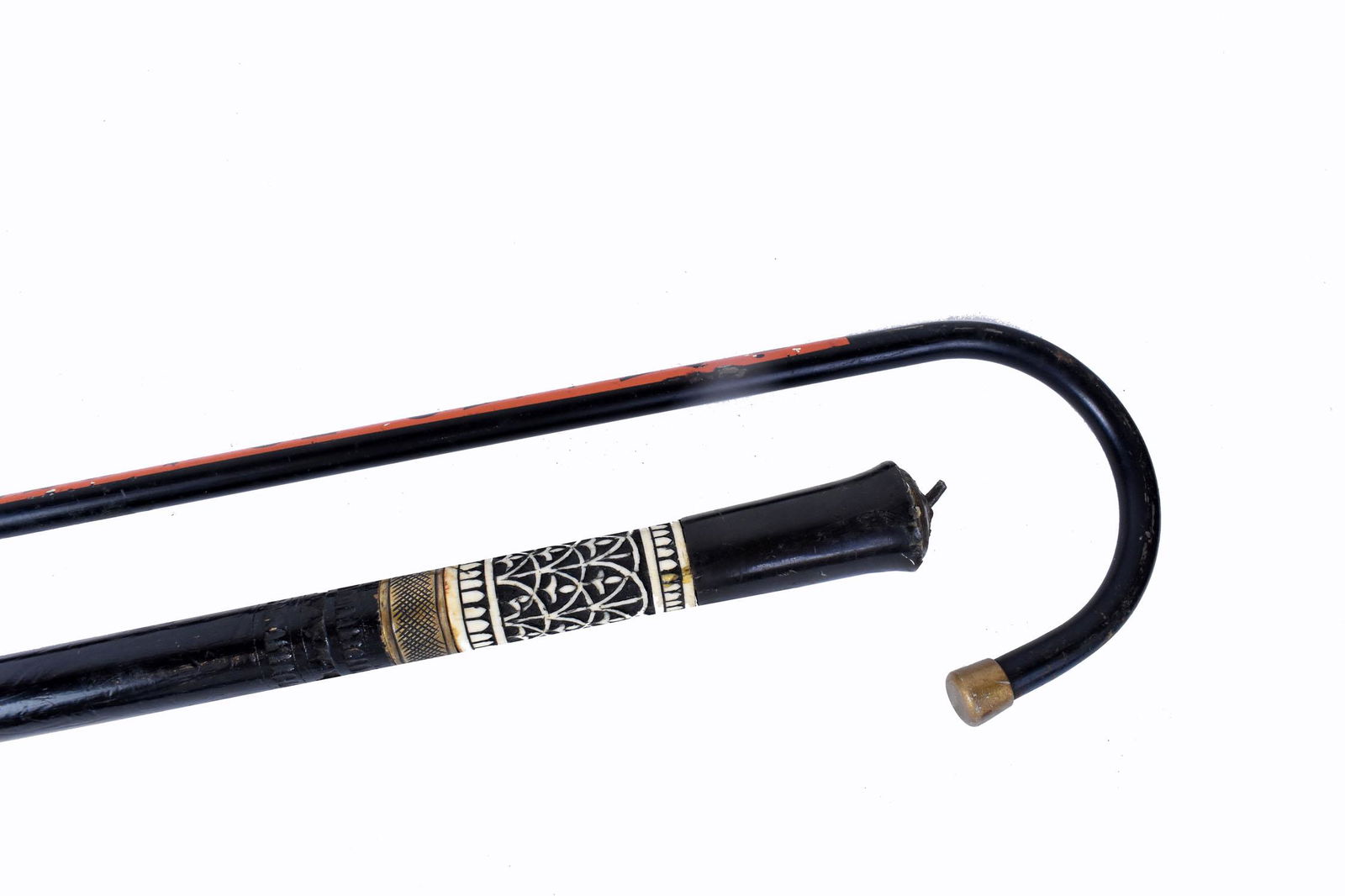 DALMATION CANE AND AN ADVERTISING WALKING STICK: Early to mid-20th Century. The first, an ebonized example opening to reveal a sword, the pommel shaped handhold, the lower portion carved with stylized foliage from bone, with a long brass ferrule; th