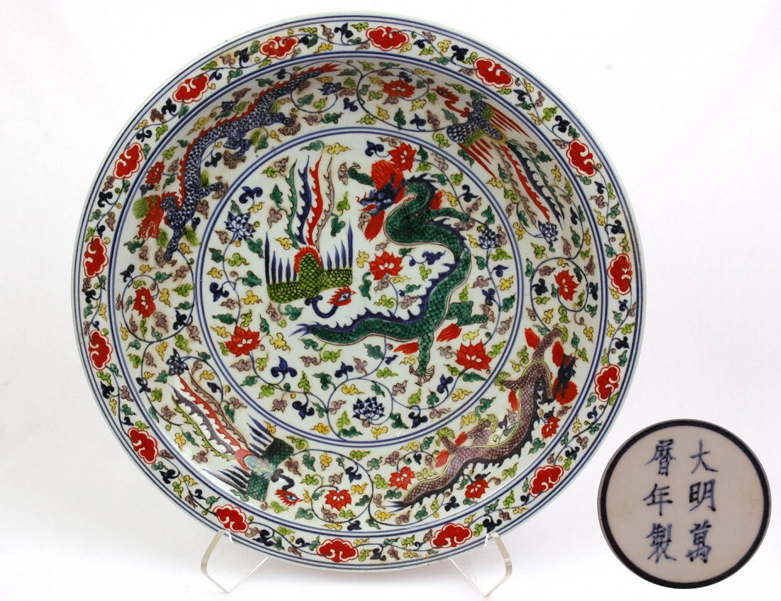 ENAMELED PORCLAIN CHARGER: Chinese. With six character Wan li mark, but of a later period. Decorated overall with dragons and phoenix birds. Diameter 16 1/4". (400/600)