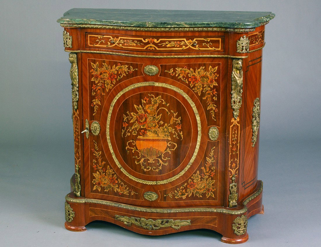 NAPOLEON III STYLE INLAID MAHOGANY SIDE CABINET: With serpentine fronted marble top above a frieze drawer and a cupboard door raised on a conforming plinth, the whole inlaid with marquetry and mounted with gilt bronze appointments. Height 40 ½". Wi