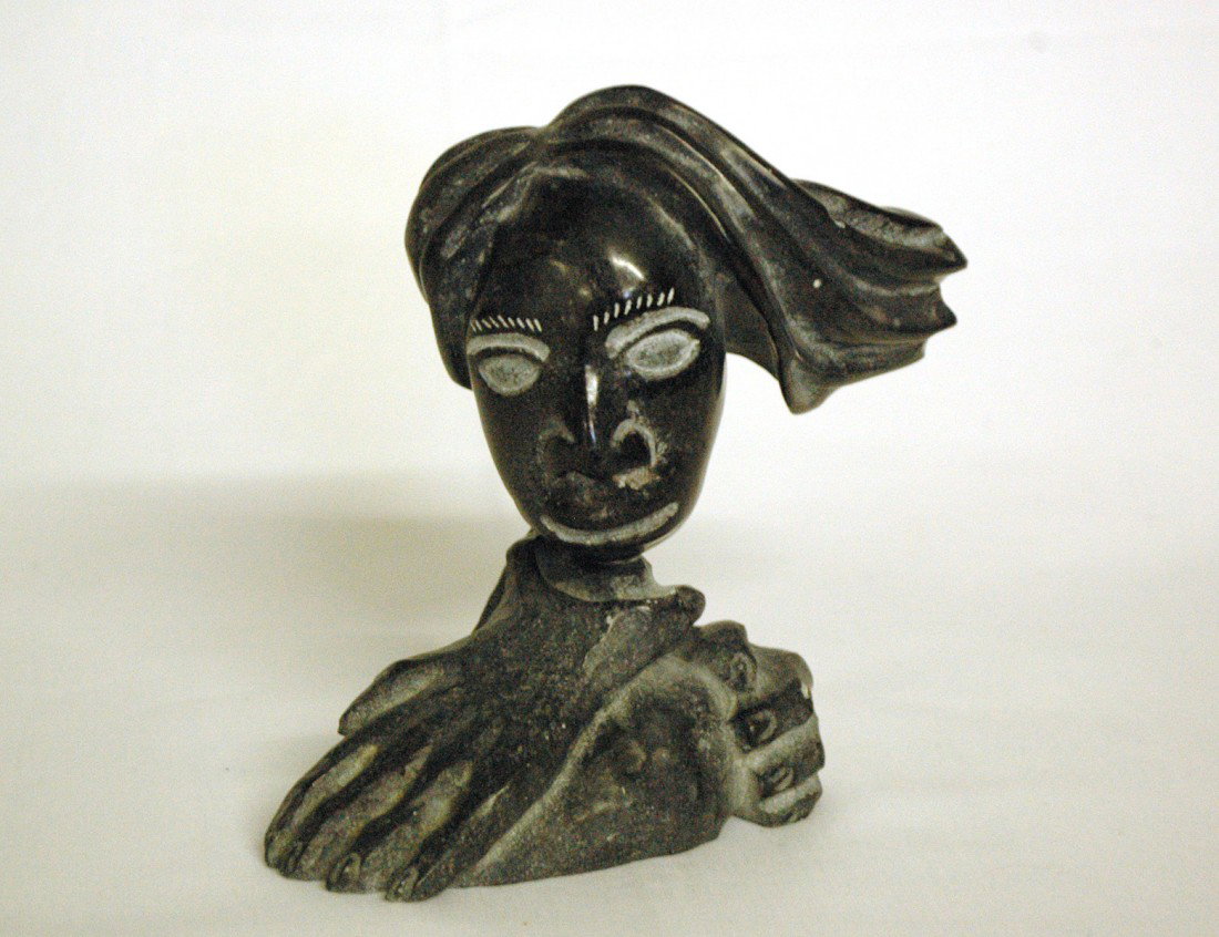 CARVED ARGILLITE SPIRIT FIGURE: Inuit. Detachable head resting on a hand emerging from a rock. Height 5 1/4". With original Canadian government label. (200/300)