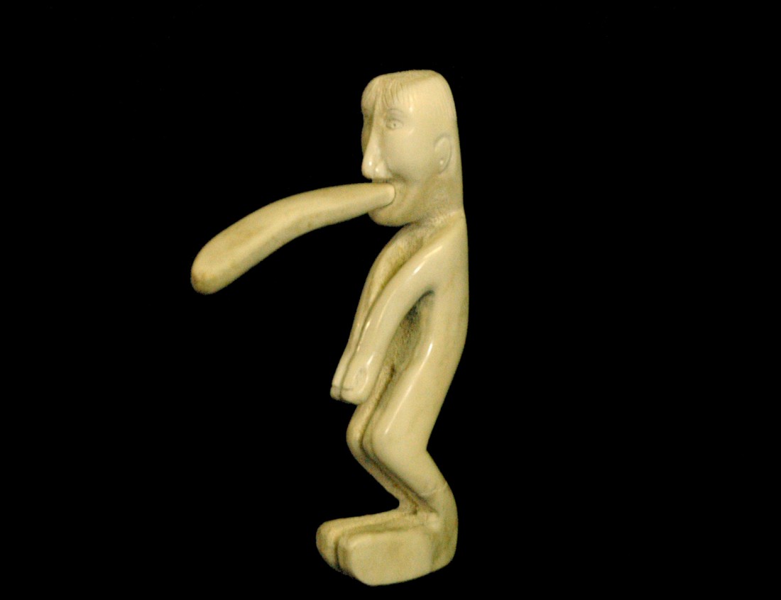 CARVED WHALE BONE MALE FIGURE: Inuit. The spirit figure with a detachable mouthpiece. Height 7". (Cond: restoration to hands) (300/400)