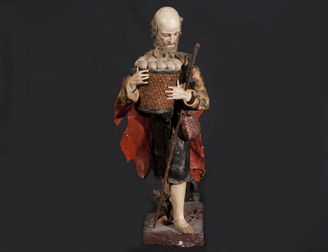 POLYCHROMED PAPIER MACHE KORESH FIGURE: Italian. 18th/19th Century. Of a bearded peasant male with a dog carrying a basket full of bread. Height 17 5/8". (Cond: restoration, losses) (500/700)