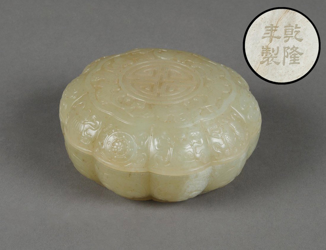 WELL CARVED WHITE JADE BOX AND COVER: Chinese. Qianlong mark and of the period. 1736-1795. Of pomegranate shape, the cover centered by a character symbol enclosed by carved foliage, bats and Shou characters. Width 3 7/8". (Cond: cover wit