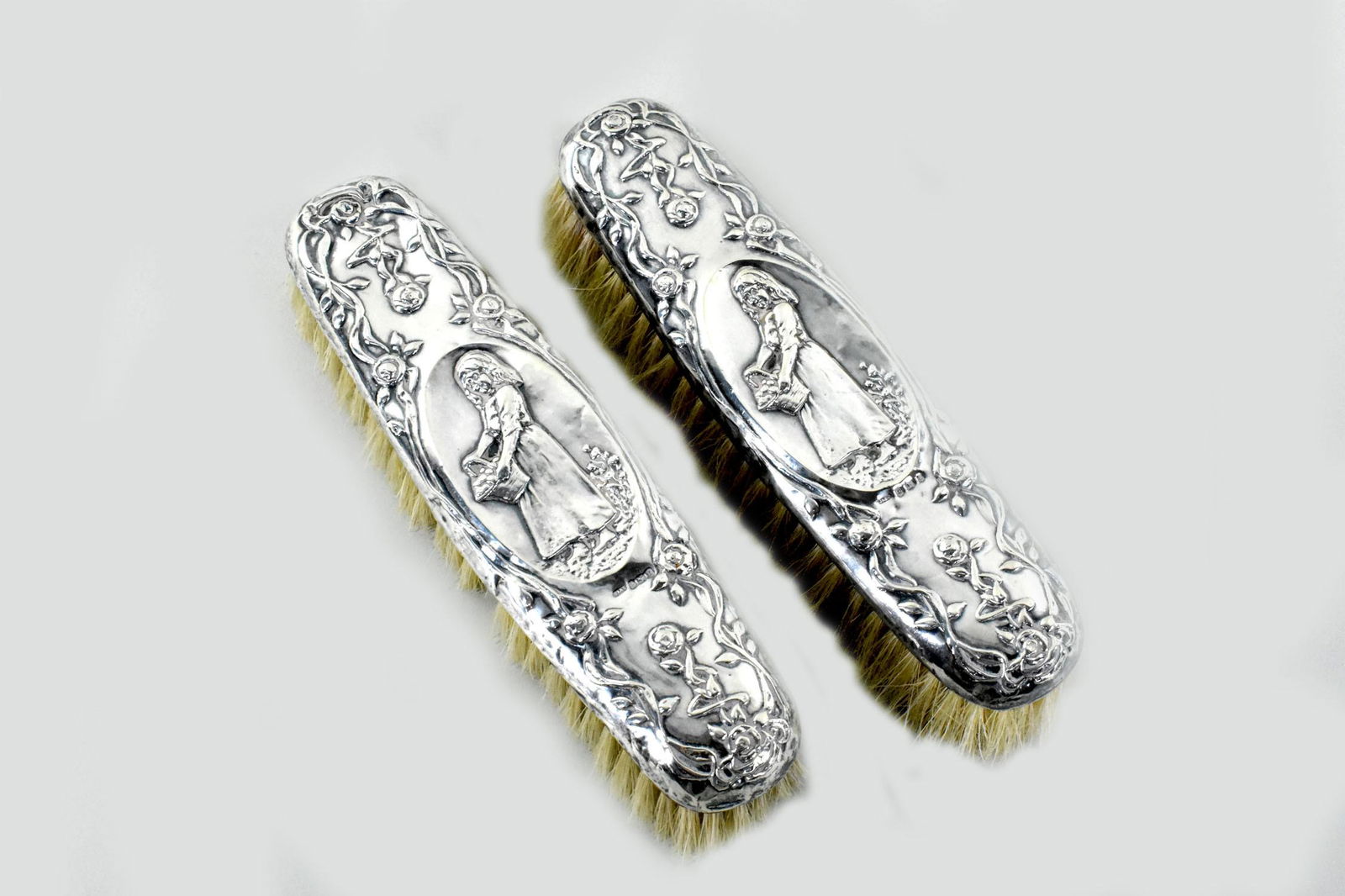 TWO BIRMINGHAM SILVER CLOTHES BRUSHES, Marked. Repousse decorated with a figure and foliage. Length (1 of 4)