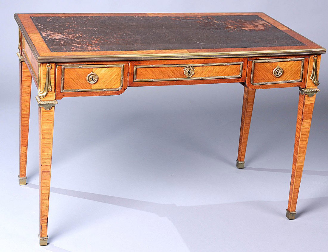 EMPIRE STYLE MAHOGANY LADY’S BUREAU PLAT: French. Circa 1920. The rectangular leather inset top above three frieze drawers, raised on square tapered legs, the whole mounted with gilt bronze borders, escutcheons and sabots. Height 28 ¾”. Wi