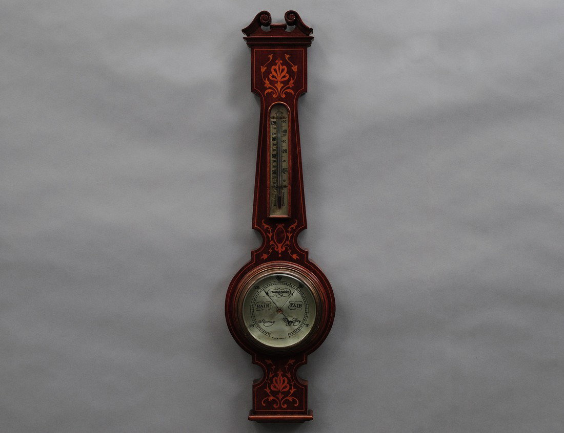 INLAID MAHOGANY BAROMETER/THERMOMETER: English. 20th Century. Of banjo shape with scroll pediment. Height 27 3/4". (200/300)