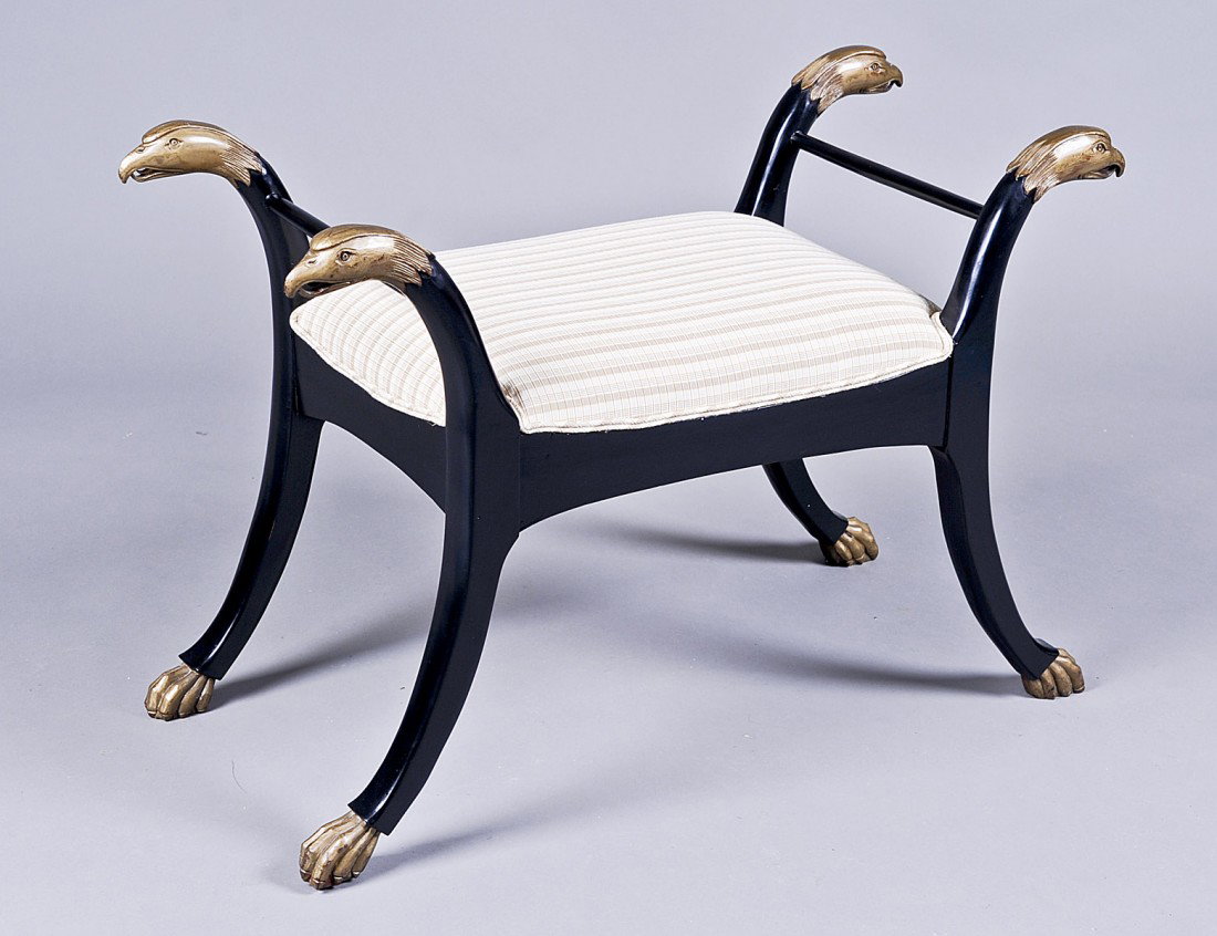 EMPIRE STYLE CARVED WOOD BENCH: The parcel gilt ebonized wood with eagle head terminals above the padded seat, raised on saber legs ending in claws. Length 37 1/4". (250/300)